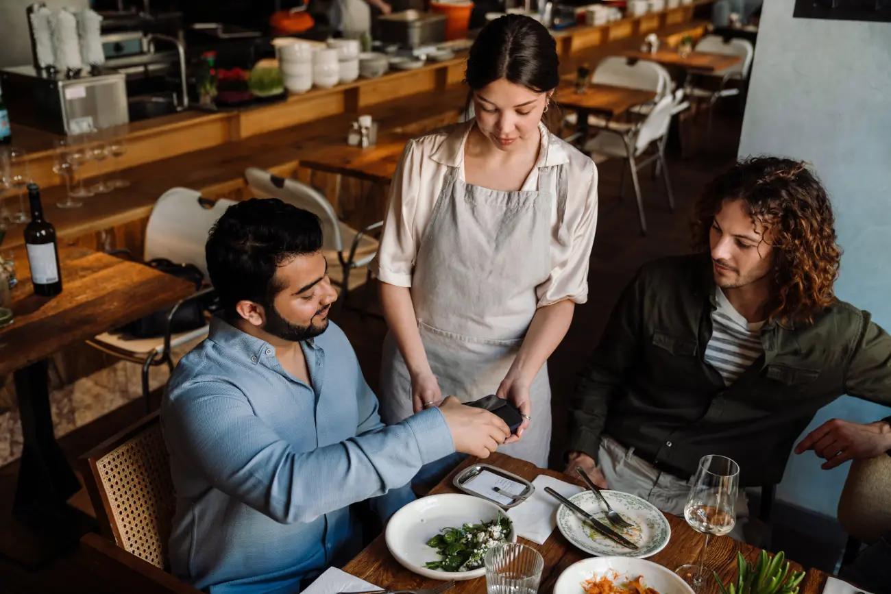 Mężczyzna płacący rachunek kartą w restauracji