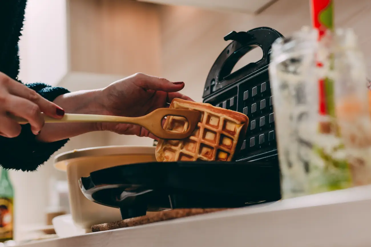 Kobieta podnosi gofra z gofrownicy