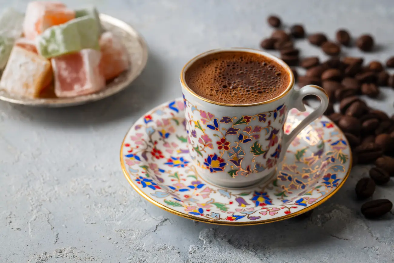 Kawa po turecku w ozdobnej filiżance z lokum i ziarnami.