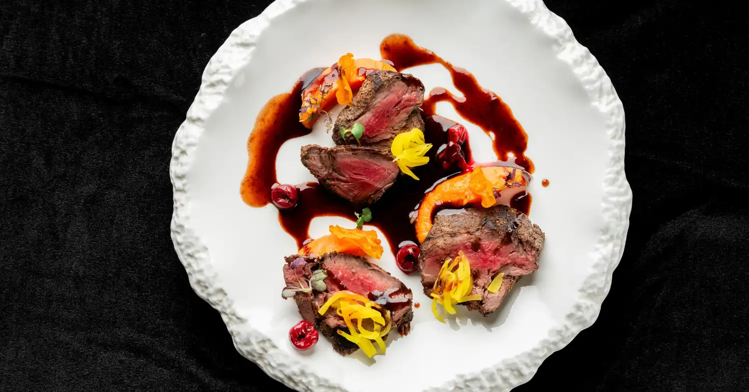 Mięso na talerzu z dodatkami i sosem jus