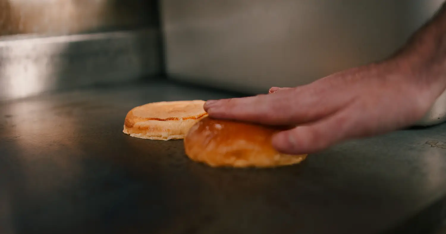 Kucharz podgrzewa bułkę 