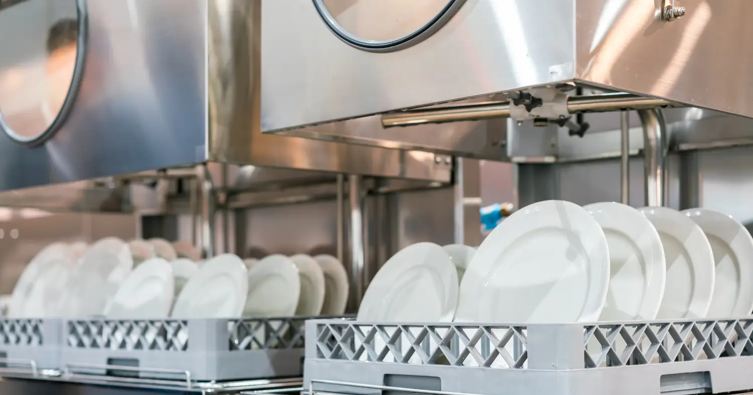 Ułożone naczynia i zmywarka gastronomiczna 