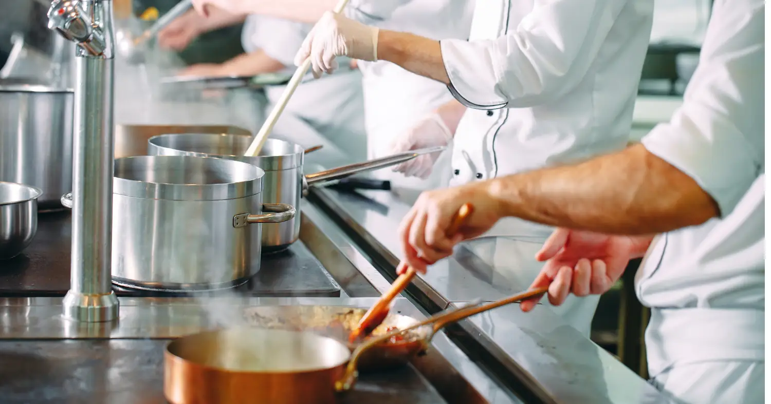 Kucharze w kuchni przygotowują danie 