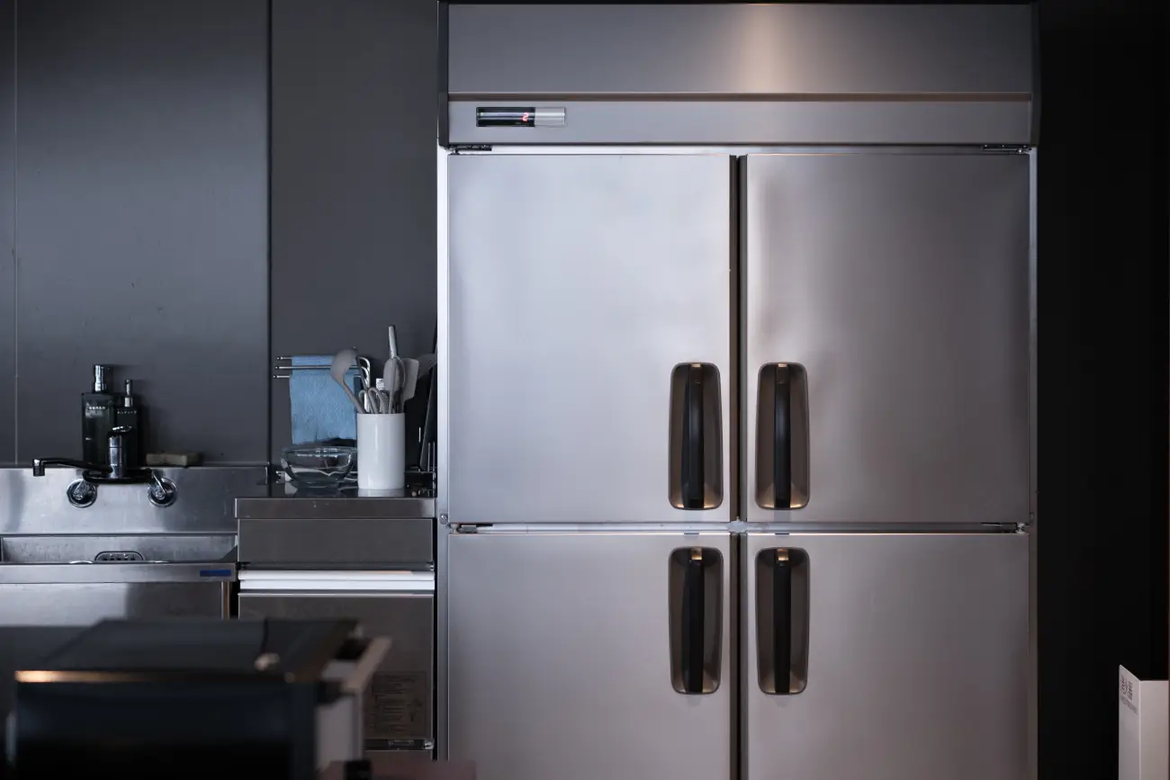 Zamknięta, czterodrzwiowa szafa chłodnicza ze stali nierdzewnej – nowoczesne wyposażenie zaplecza gastronomicznego.