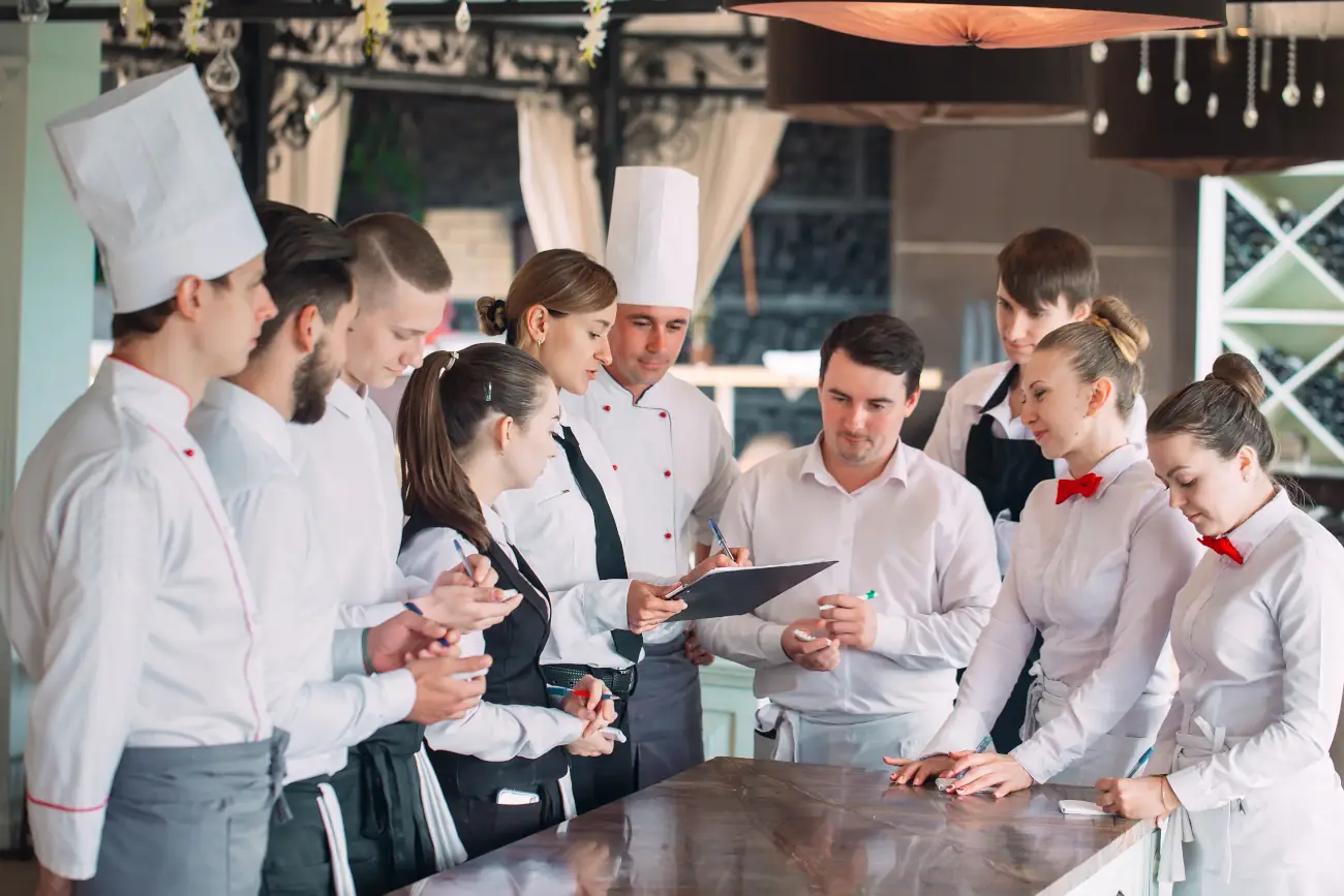 Zespół restauracyjny – kucharze i kelnerzy – omawia grafik lub plan urlopów.
