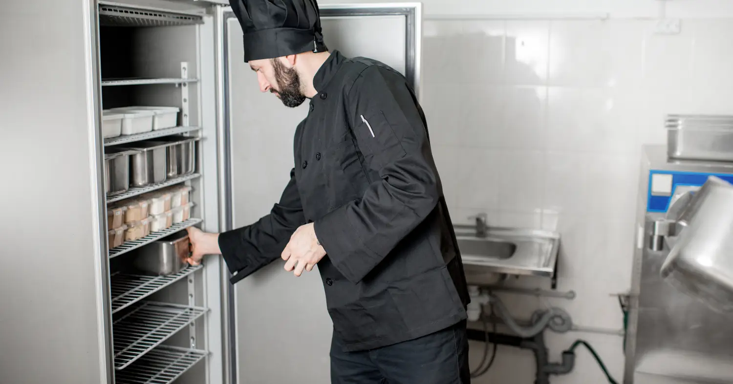 szef kuchni wyjmuje jedzenie w pojemniku z lodówki