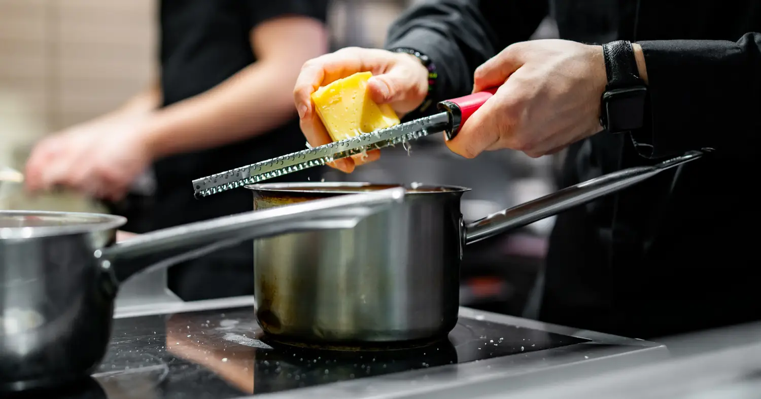 kucharz trze ser do dania w garnku