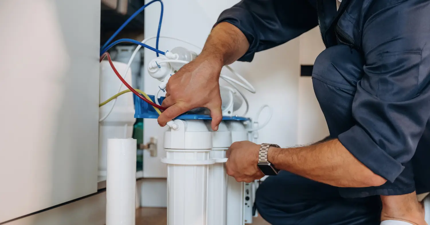 pracownik wymienia filtr do wody 