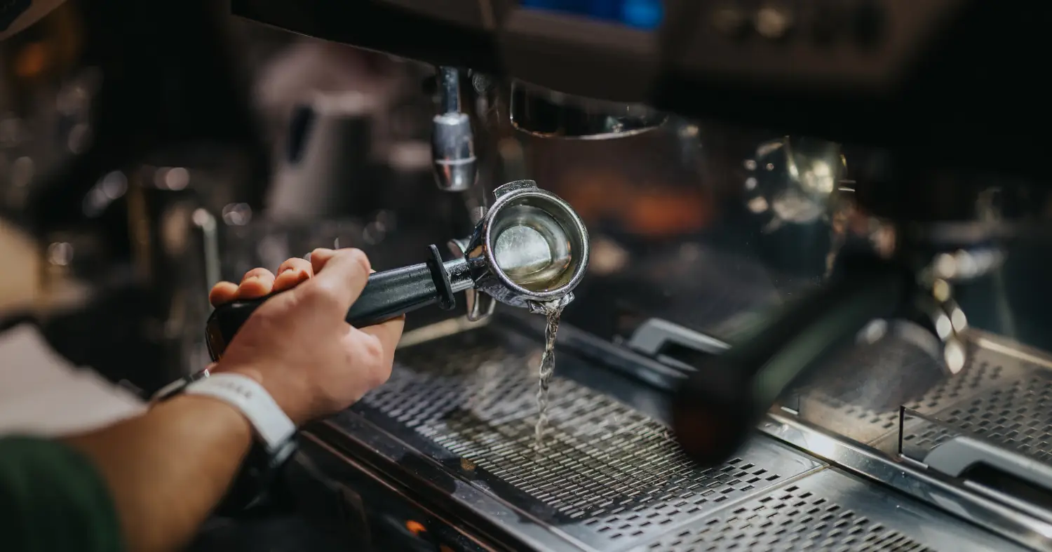 barista płucze narzędzie wodą