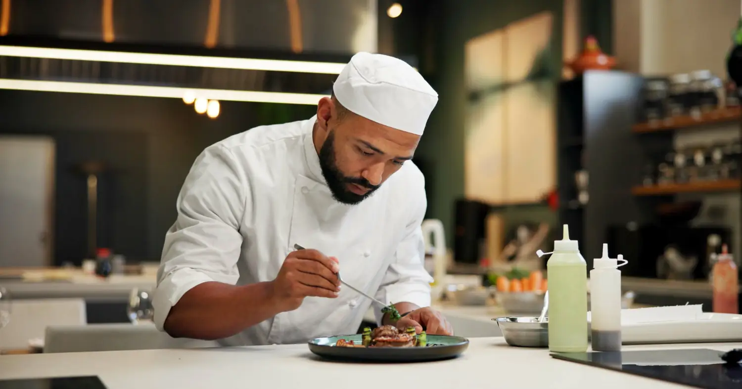 szef kuchni dokańcza potrawę