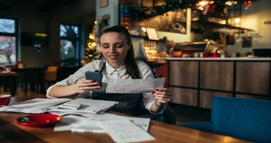 Kobieta w restauracji siedząca przy stole z dokumentacją
