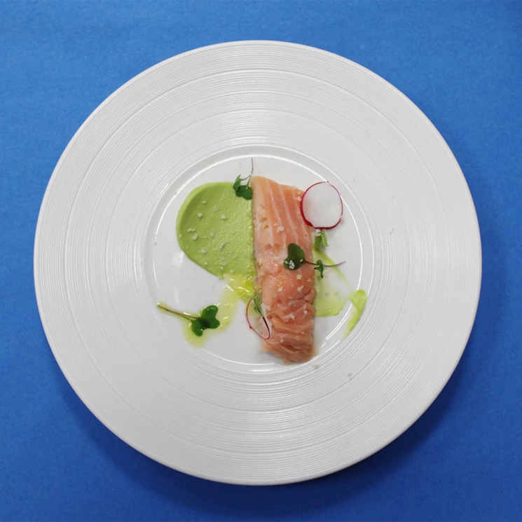 Elegancko podany łosoś mi-cuit na białym talerzu, z musem z zielonego groszku, rzodkiewką i mikroziołami – nowoczesna przystawka serwowana w stylu fine dining.