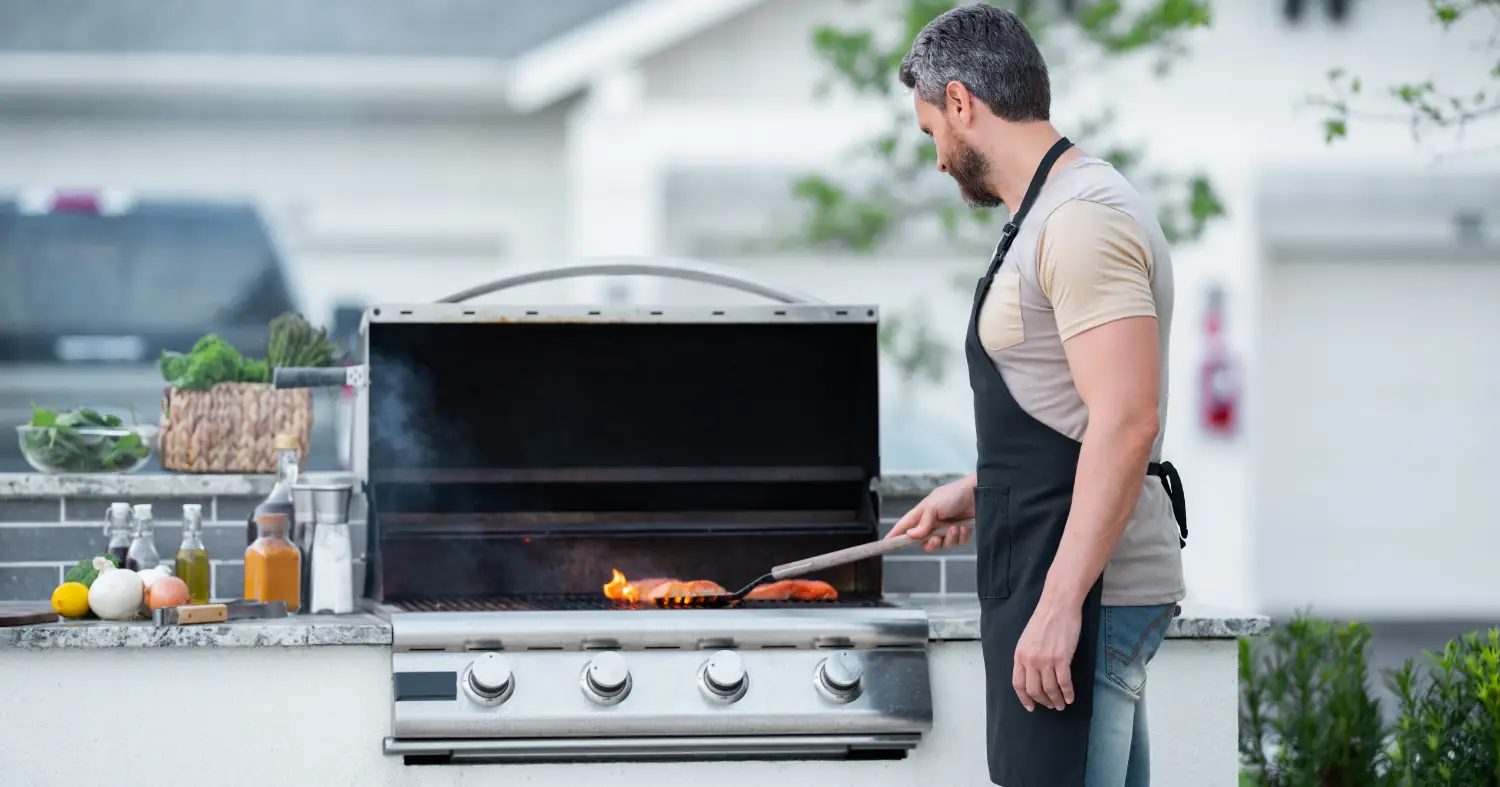 mężczyzna grilluje na grillu gazowym