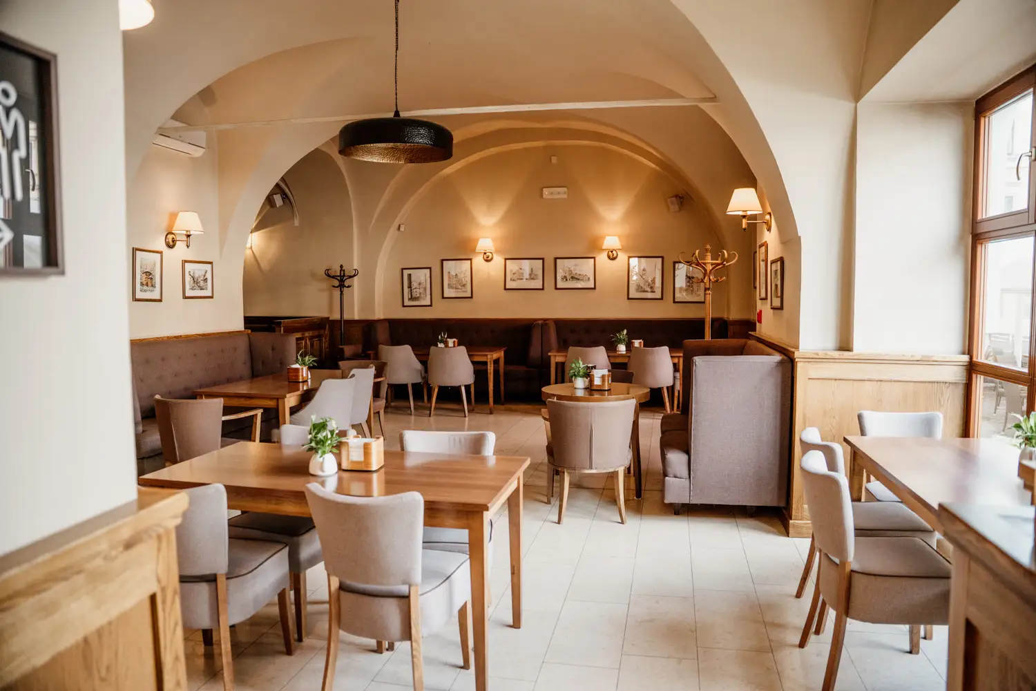 Wnętrze eleganckiej sali restauracyjnej w Kamienicy Konczakowskich z miejscami do siedzenia.