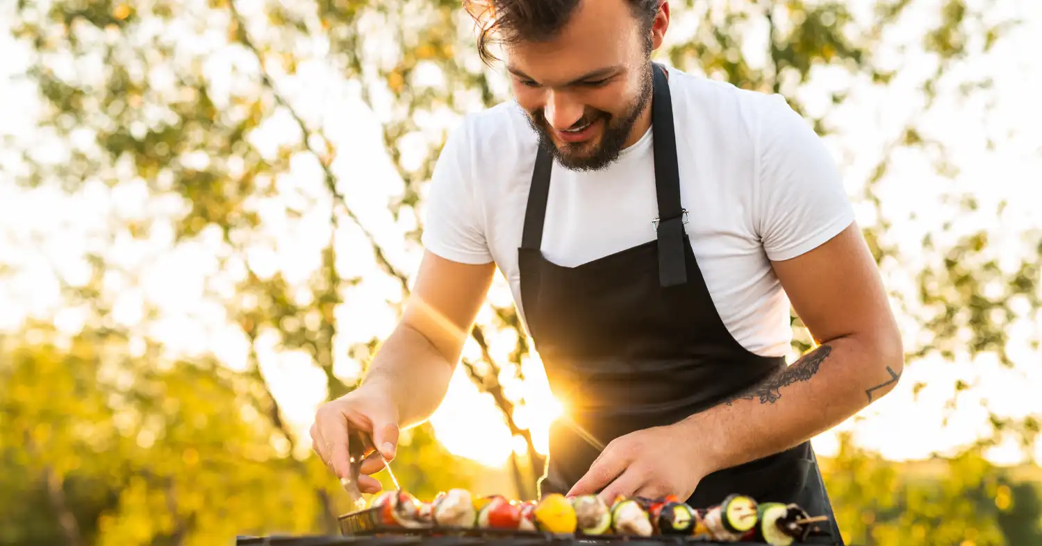 Mężczyzna przygotowuje przekąski na grillu