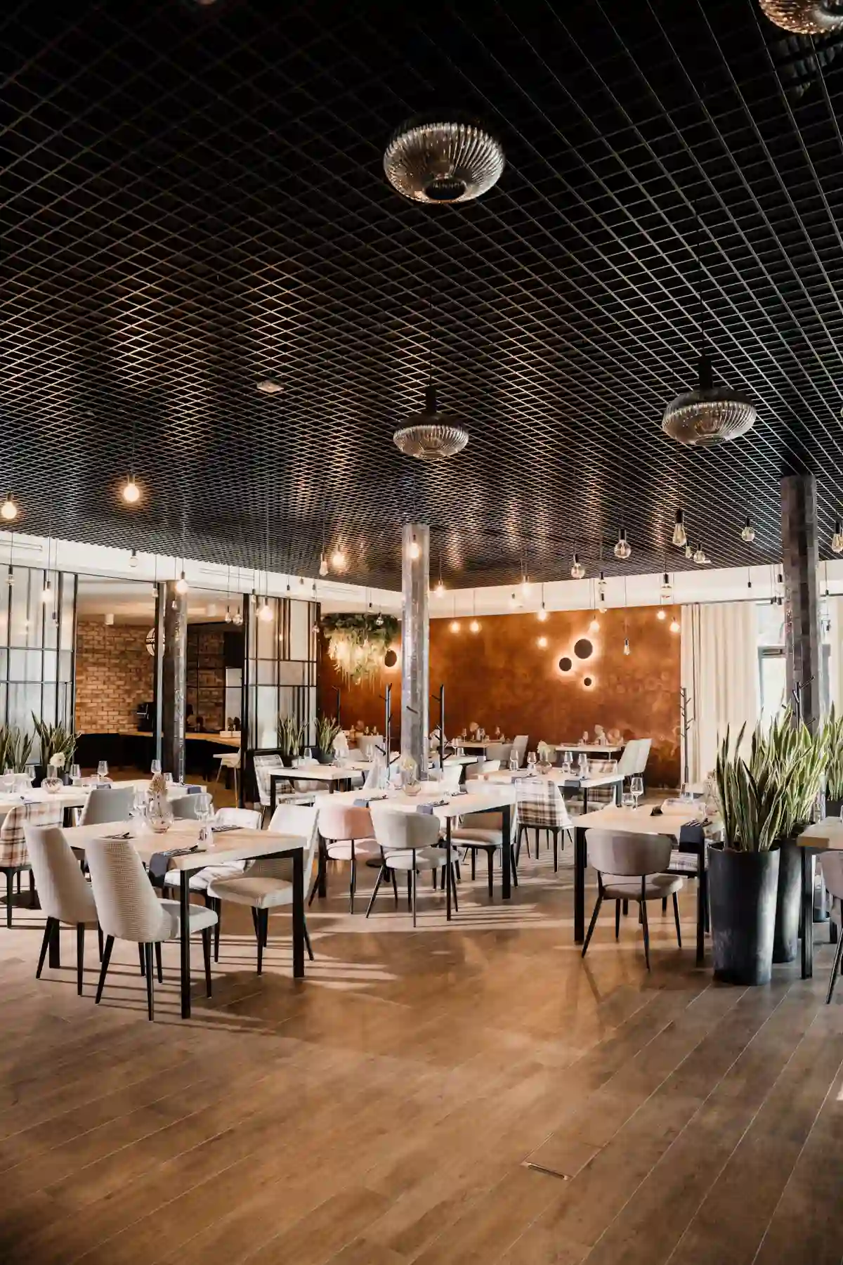 Przestronna sala restauracji Rudy Las z eleganckimi stolikami, designerskim oświetleniem i nowoczesnym wnętrzem