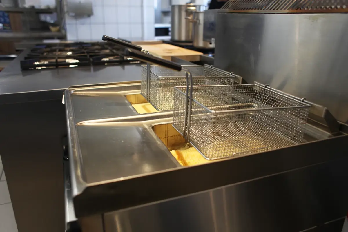Profesjonalna frytkownica gastronomiczna z dwiema komorami i koszami do smażenia.