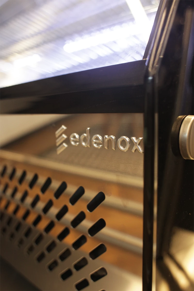 Detal witryny chłodniczej Edenox z widocznym logo producenta oraz perforowaną osłoną wentylacyjną. Urządzenie przeznaczone do ekspozycji i przechowywania produktów spożywczych w gastronomii.
