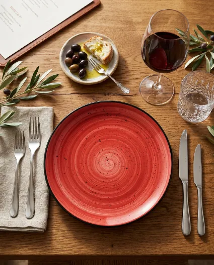 Porcelanowy talerz BONNA  w eleganckim nakryciu stołu restauracyjnego z sztućcami i szkłem.