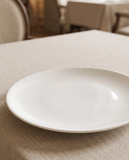 orcelana Bonna na restauracyjnym stole w eleganckiej aranżacji, podkreślającej nowoczesne wzornictwo, trwałość oraz premium jakość zastawy stołowej.