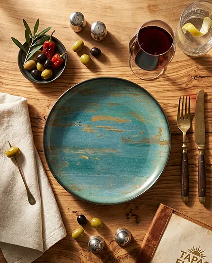 Porcelanowy talerz BONNA  w eleganckim nakryciu stołu restauracyjnego z sztućcami i szkłem.
